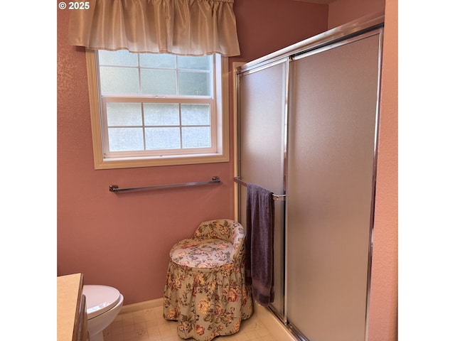 bathroom featuring vanity, baseboards, a shower stall, and toilet
