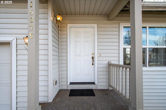 entrance to property featuring a garage and covered porch