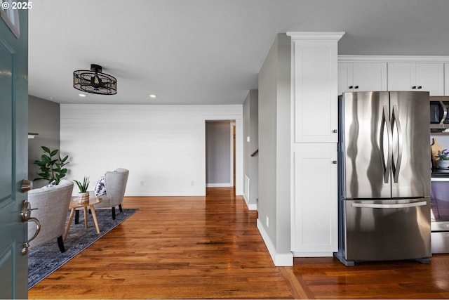 kitchen with recessed lighting, white cabinets, appliances with stainless steel finishes, and wood finished floors