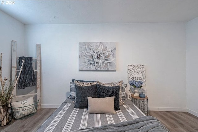 bedroom featuring baseboards and wood finished floors