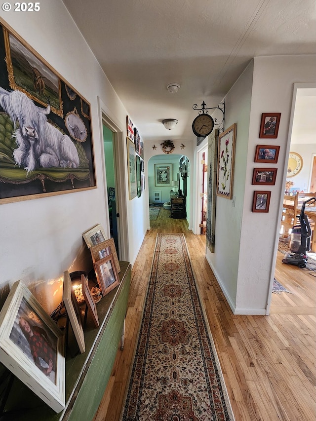 hall with wood-type flooring and arched walkways