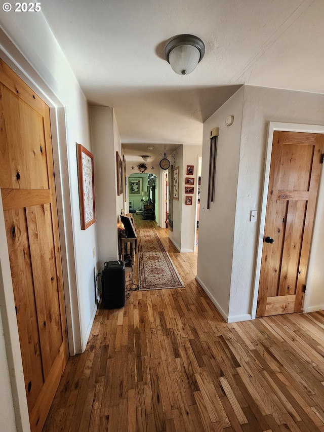 hallway with hardwood / wood-style floors and baseboards