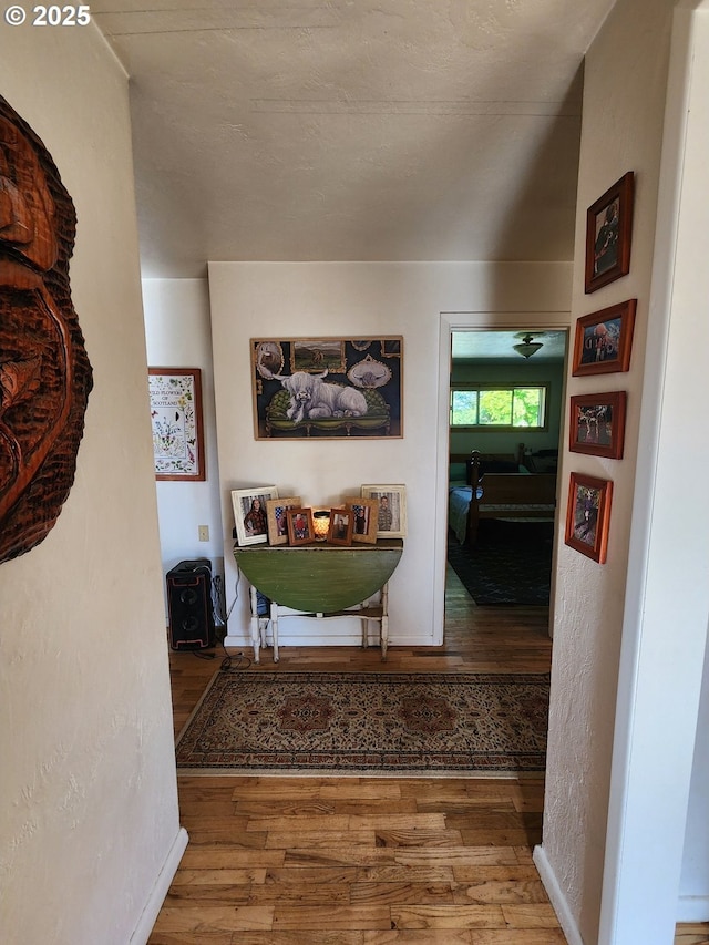 hall with wood finished floors and baseboards