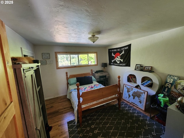 bedroom with wood finished floors and a textured ceiling