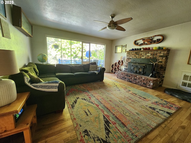 living area featuring hardwood / wood-style flooring, a ceiling fan, and a textured ceiling