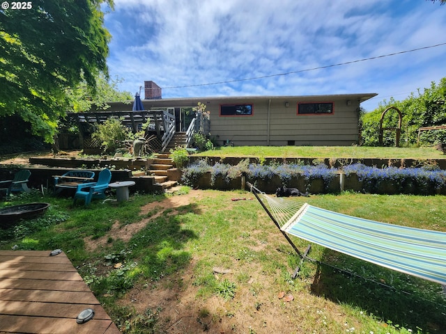 back of house featuring a yard, a wooden deck, and stairs