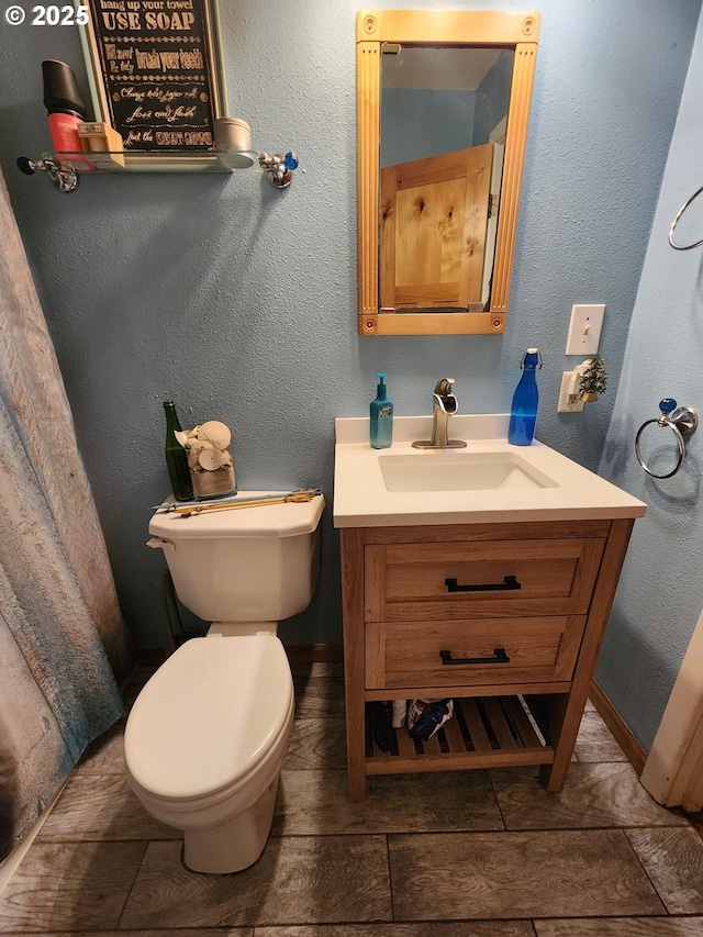 half bathroom featuring vanity and toilet
