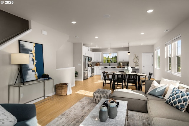 living room featuring sink and light hardwood / wood-style floors