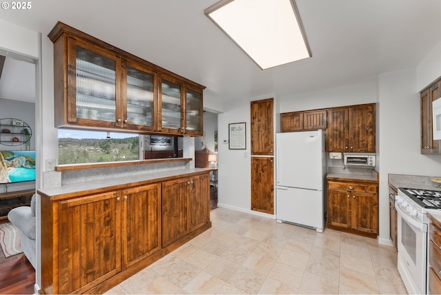 kitchen with white appliances, glass insert cabinets, and baseboards