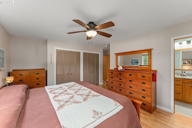 bedroom featuring visible vents, multiple closets, connected bathroom, light wood-style floors, and ceiling fan