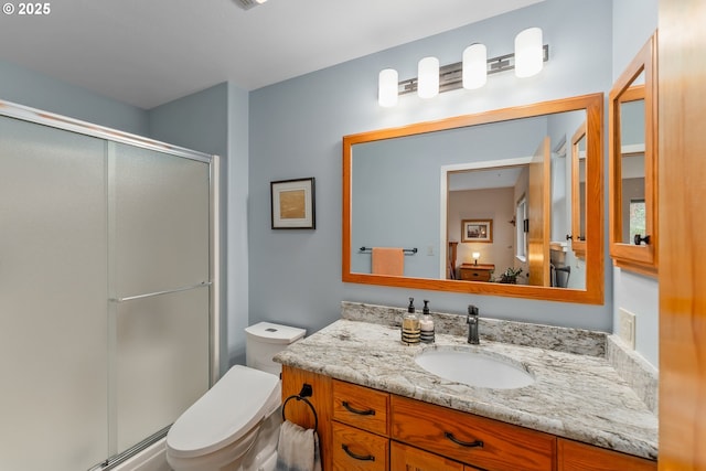 full bathroom featuring toilet, a stall shower, and vanity