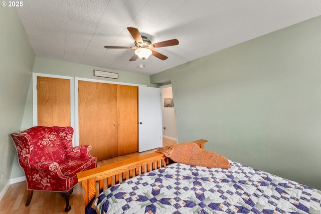 bedroom with ceiling fan, baseboards, and wood finished floors