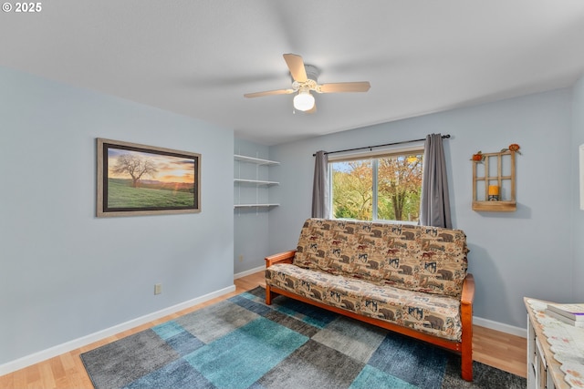 sitting room featuring a ceiling fan, baseboards, and wood finished floors