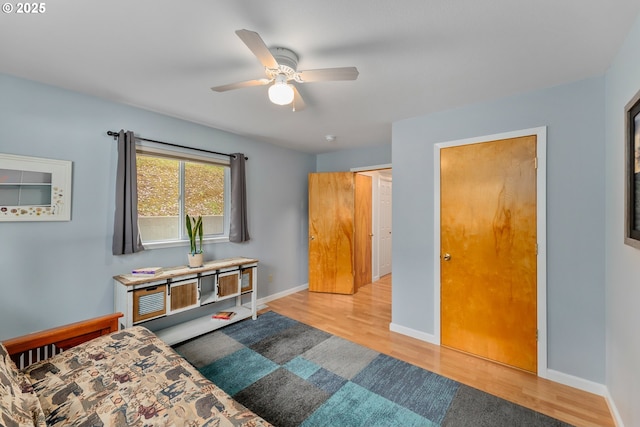 bedroom featuring ceiling fan, baseboards, and wood finished floors