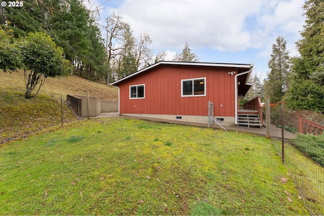 back of property featuring a yard, fence, and crawl space