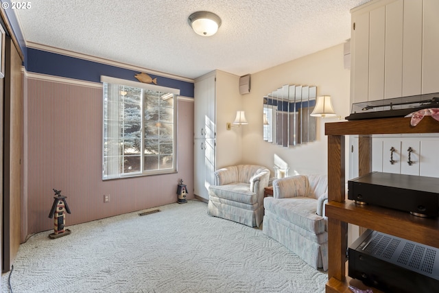 sitting room featuring carpet floors and a textured ceiling