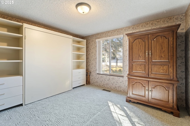 interior space with light colored carpet and a textured ceiling