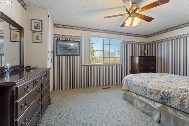 carpeted bedroom featuring ceiling fan and a textured ceiling