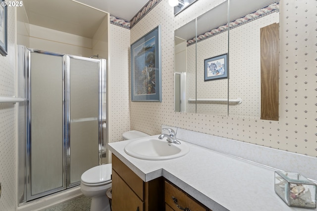 bathroom featuring vanity, a shower with door, and toilet