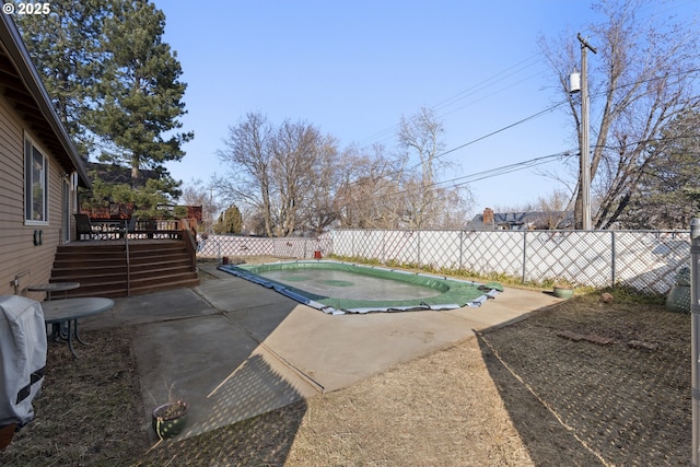 view of swimming pool featuring a patio and a deck