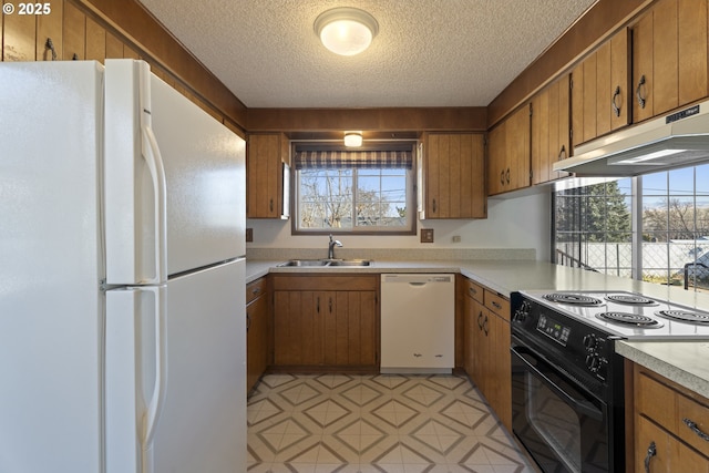 kitchen with white appliances, sink, and a textured ceiling