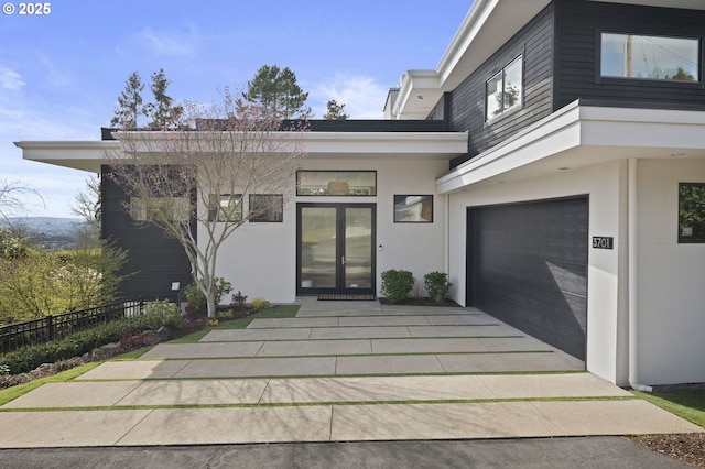 3701 SW 38th Ave, Portland, OR 97221 - property entrance with stucco siding, an attached garage, and driveway