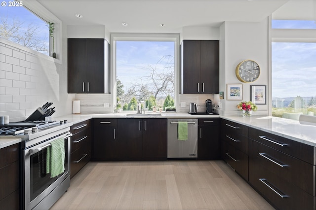 3701 SW 38th Ave, Portland, OR 97221 - kitchen with stainless steel appliances, modern cabinets, backsplash, light wood-style floors, and recessed lighting