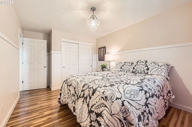 bedroom featuring baseboards, wood finished floors, and a closet