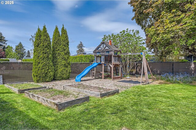 view of jungle gym with a yard, a fenced backyard, and a vegetable garden