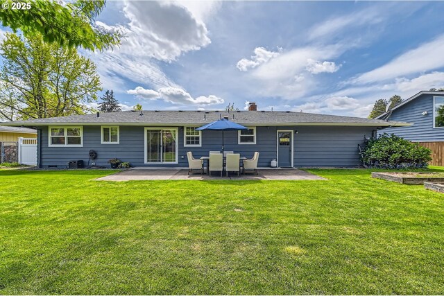 back of property with a patio, a lawn, and fence