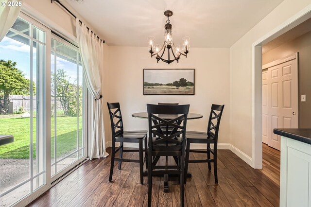 dining space with baseboards, a notable chandelier, dark wood-type flooring, and a wealth of natural light