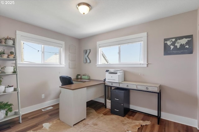 office space with a healthy amount of sunlight, light wood finished floors, and visible vents