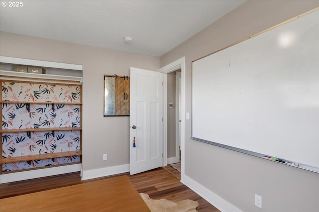 corridor with wood finished floors and baseboards