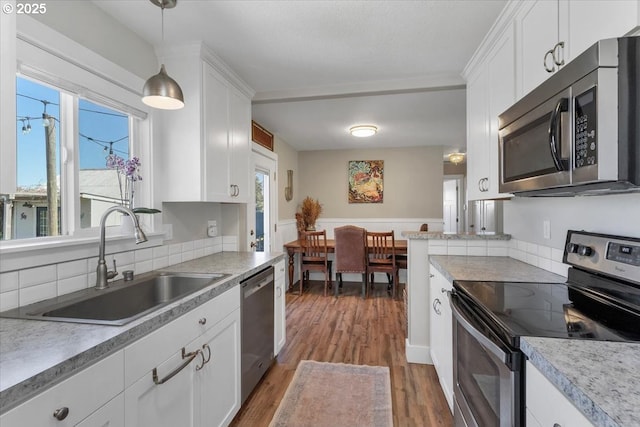 kitchen featuring appliances with stainless steel finishes, a sink, and white cabinetry