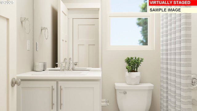 bathroom featuring a shower with shower curtain, vanity, and toilet