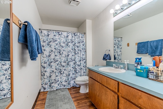 bathroom with wood-type flooring, toilet, and vanity