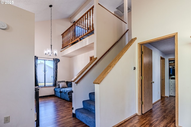 stairs with an inviting chandelier, hardwood / wood-style floors, and a high ceiling