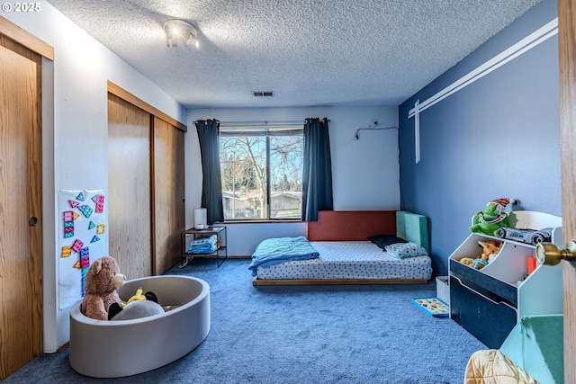 bedroom with carpet floors, a closet, and a textured ceiling