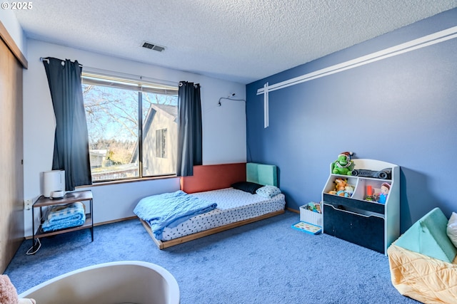 bedroom featuring carpet floors and a textured ceiling