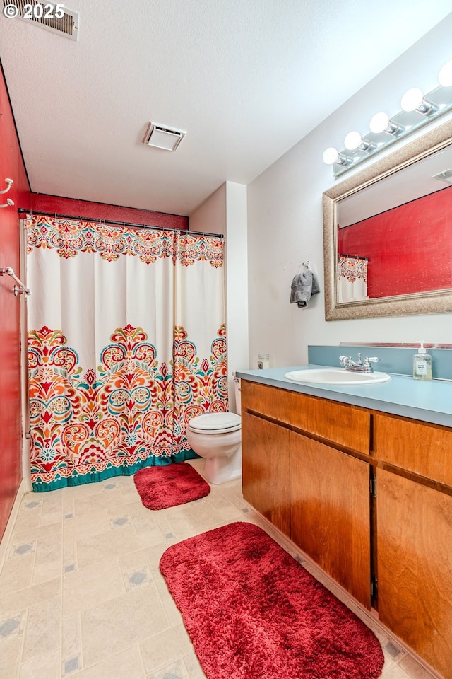 bathroom with vanity, a textured ceiling, and toilet