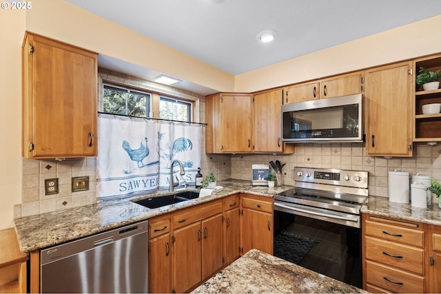 kitchen with light stone counters, sink, tasteful backsplash, and stainless steel appliances