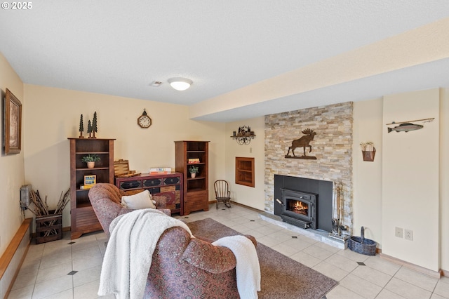 living room featuring light tile patterned flooring, a stone fireplace, and a textured ceiling