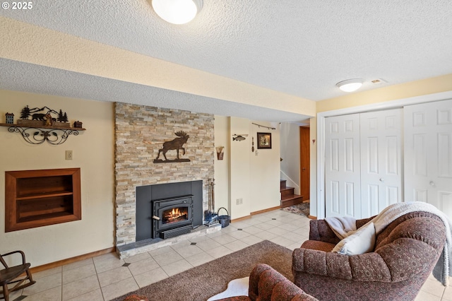 living room featuring a stone fireplace, a textured ceiling, and light tile patterned floors