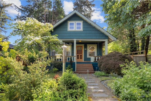 view of front of property with a porch and fence