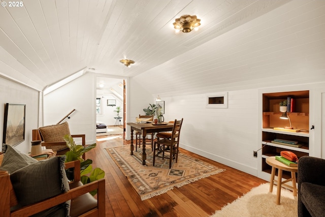 dining space with baseboards, vaulted ceiling, wooden ceiling, and hardwood / wood-style floors