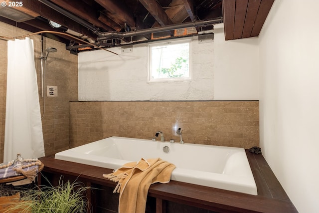 bathroom featuring a bathing tub and a tile shower