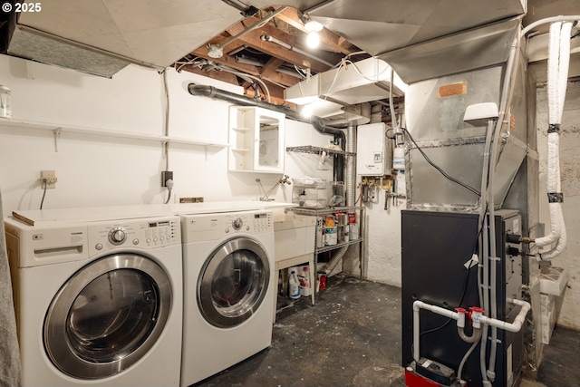 laundry room with independent washer and dryer, laundry area, and water heater
