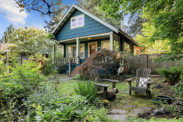 bungalow-style house with a porch and fence