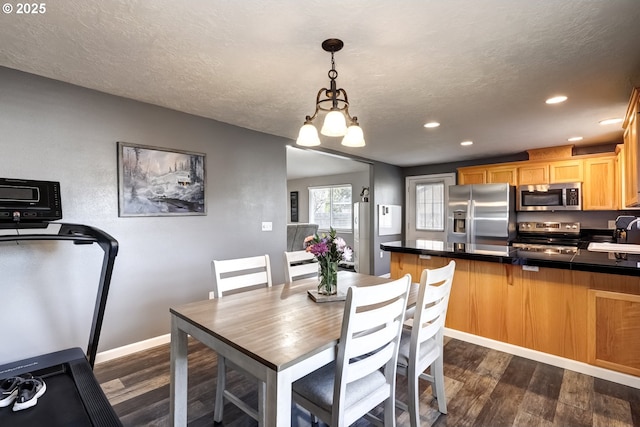 dining room with recessed lighting, dark wood finished floors, a textured ceiling, and baseboards