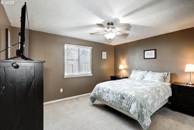 bedroom with a textured ceiling, carpet flooring, visible vents, and baseboards